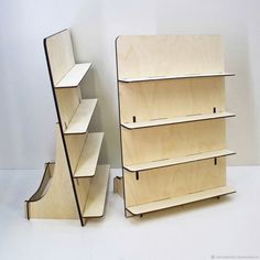 two bookshelves sitting next to each other on a white floor in front of a wall