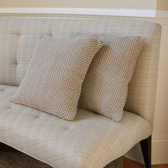 two pillows sitting on top of a couch