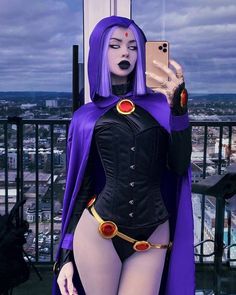 a woman dressed in purple and black is taking a selfie with her cell phone