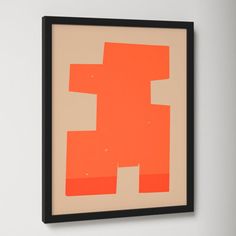 an orange piece of art hanging on the wall