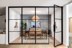 an open glass door leading into a dining room