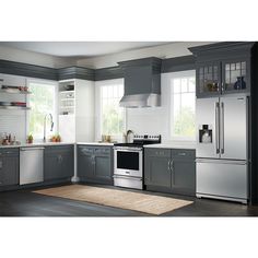 a modern kitchen with stainless steel appliances and gray cabinetry, including an area rug