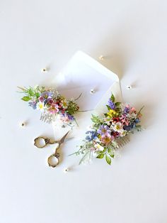 two flowers and scissors on a white surface