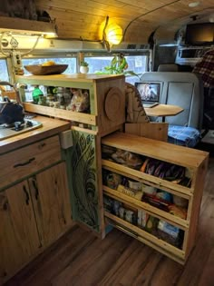 the inside of a camper with wooden cabinets and drawers