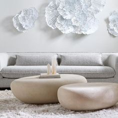 a modern living room with white furniture and large paper flowers on the wall above it