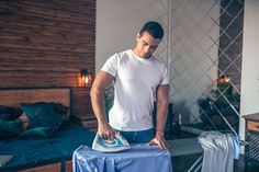 a man ironing clothes on an ironing board