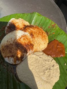 some sort of food on a green plate with sauces and powdered sugar in it