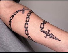 a person with a tattoo on their arm holding a knife and chain around his arm