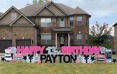 a happy birthday sign in front of a large brick house with lots of decorations on it