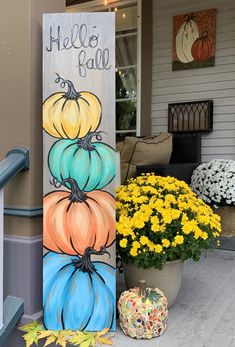 a painted sign that says hello fall with pumpkins on it and yellow flowers in the background