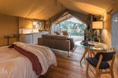 a bed sitting inside of a tent next to a living room