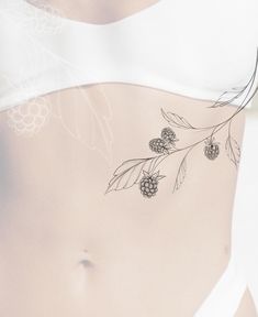 a woman's stomach with flowers and leaves drawn on the bottom of her belly