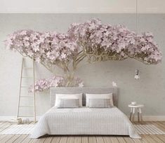 there is a bed with flowers on the headboard and pillows in front of it