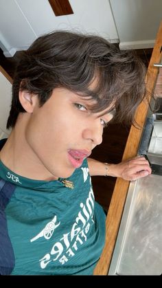 a young man sticking his tongue out in front of an oven