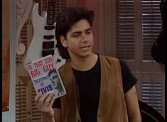 the young man is holding up his book