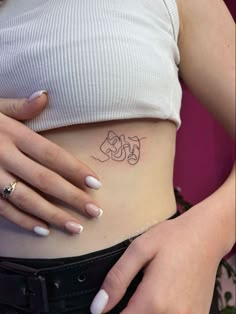 a woman's stomach with a small tattoo on her belly and the word love written in cursive letters