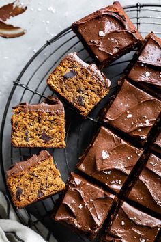 several pieces of chocolate cake sitting on a wire rack next to some slices cut into squares