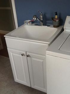 a white washer and dryer sitting next to each other in a room with blue walls