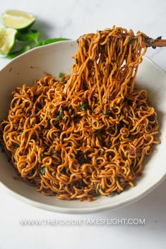 a white bowl filled with noodles on top of a table