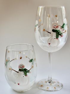 two wine glasses with snowmen painted on them