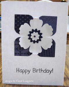 a birthday card with a white flower on the front and dark blue stripes in the back