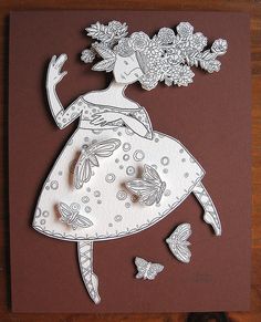 a paper cut out of a woman with flowers on her head and butterflies around her neck