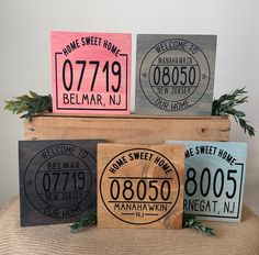 four wooden signs with names on them sitting on top of a table in front of a potted plant