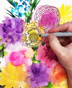 someone is drawing flowers on a piece of watercolor paper with a marker and pen