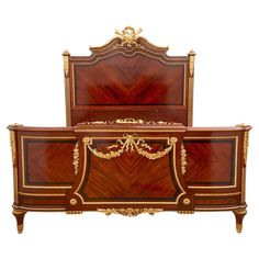 an ornately decorated wooden bed with gold trimmings