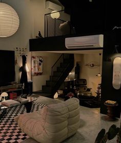 a living room with black and white checkered flooring in the foreground is a staircase leading up to an upper level loft