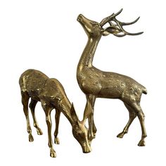 two brass deer statues standing next to each other