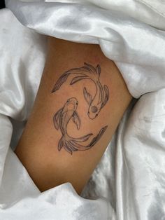 a woman with a tattoo on her leg that has two koi fish in it