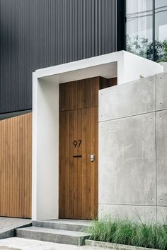 an entrance to a modern house with wooden doors