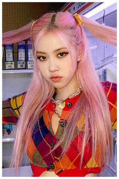 a woman with long pink hair standing in front of a counter