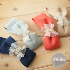 four different colored bows with pearls on them