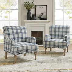 two plaid chairs in front of a fireplace with vases on the mantel above