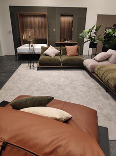 a living room filled with lots of couches and pillows on top of carpeted flooring