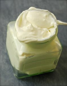 a spoon is in a small jar of cream