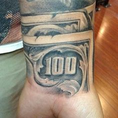 a man's hand with a tattoo on it that has money in the middle