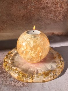 a candle is sitting on top of a piece of rock and it's light shines in the middle