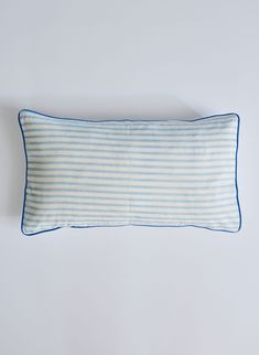 a blue and white striped pillow sitting on top of a table