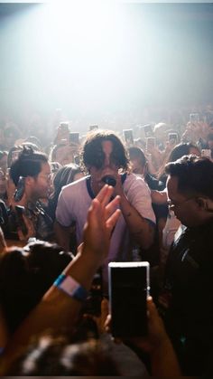 a crowd of people are taking pictures with their cell phones at a music festival or concert