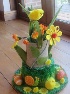 an arrangement of fake flowers in a pot on the floor