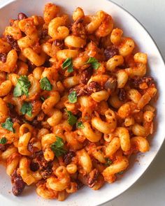 a white bowl filled with pasta and meat