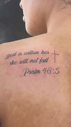 the back of a man's shoulder with a cross and bible verse on it