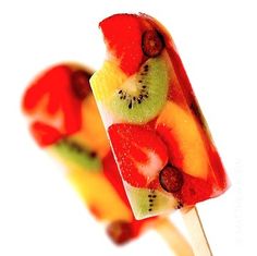 fruit lollipops with kiwi, banana, and orange slices on them