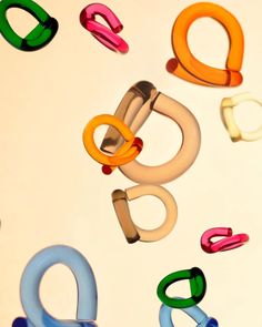 the letters q are made up of different colored plastic handles and clips on a white surface