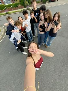 a group of young people standing in the middle of a street with their hands together