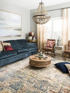 a living room filled with furniture and a chandelier hanging over the top of it