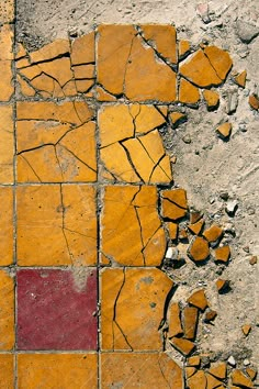 an orange and red tile on the side of a road that has been cracked in half